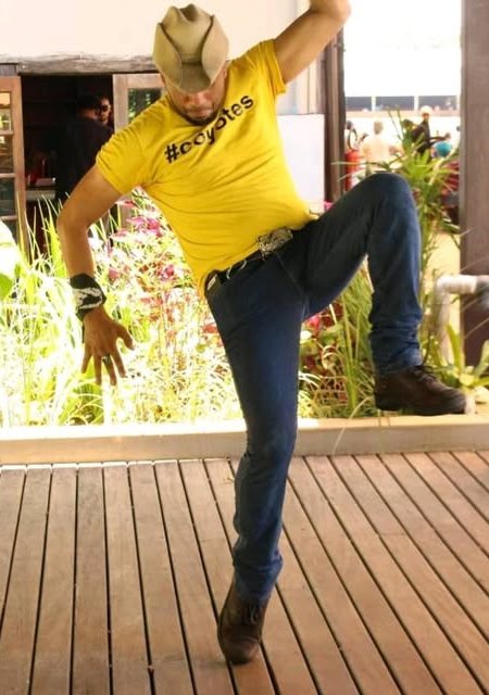 Sam Coyotes dançando Line Dance, com chapéu e bota
